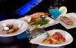 A live blue crab crawls up to say hello to a crabcake of his fallen brothers, surrounded by pan-seared red snapper, Alaskan king crab, jumbo snow crab claws, and an Electric Blue Martini. Tony Robles