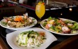 Green chile lasagna (front), Venezuelan paella (left), Caribbean shrimp salad — and a Leenero — beckon you to Mijo’s Fusion. Tony Robles