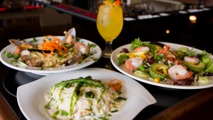 Green chile lasagna (front), Venezuelan paella (left), Caribbean shrimp salad — and a Leenero — beckon you to Mijo’s Fusion. Tony Robles