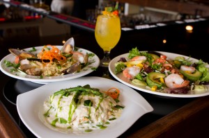 EATS Green chile lasagna (front), Venezuelan paella (left), Caribbean shrimp salad — and a Leenero — beckon you to Mijo’s Fusion. Tony Robles