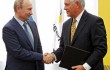 ExxonMobil CEO Rex Tillerson (right) shakes hands with Russian President Vladimir Putin