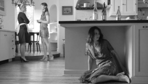 Amy Acker (under counter) hides from her friends’ conversation about her love life in Much Ado About Nothing.
