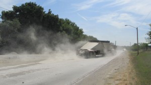 Another truck raises another cloud of dust on East First Street. Mike Phipps