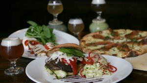 Along with a flight of house beers, Zio Carlo offers a mozzarella caprese appetizer (left), a portobello melt with pasta salad, and a scrumptious brie-and-speck pizza.