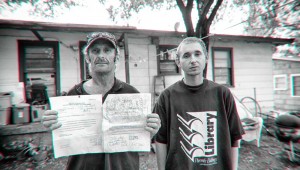 Charles Carroll (left), with R.J. Logan, holds his notice to vacate, to which he has added his own comments. Brian Hutson