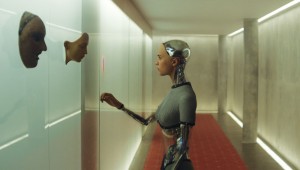 Alicia Vikander ponders the faces of the prototypes before her in Ex Machina.
