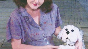 Christina Cranshaw pets a fake dog in Hip Pocket Theatre’s Lili.