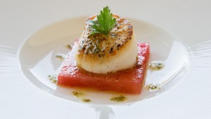 A perfect scallop St. Jaques sits on a slice of watermelon. (Courtesy of Farrar Food Photography).