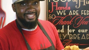 Co-owner Demarcus Davis serves one of Taste N See’s signature chicken and waffle dishes. Photo by Lee Chastain.