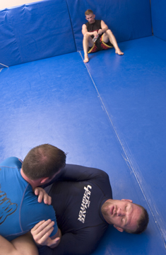 Lutter, on the bottom, uses jiu jitsu moves to reverse the situation.