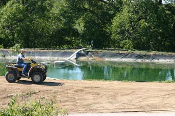 A property owner checks out a holding pond that gas drillers are using to ‘frac’ the Barnett Shale.