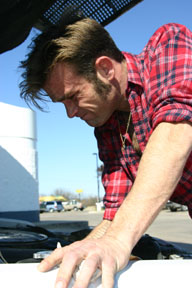 Payne checks his engine oil before heading back on the road.