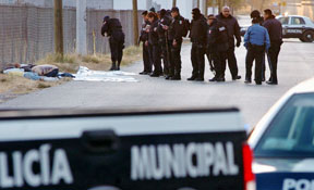 Police officers survey the area in Juarez where the bodies of seven men, all shot in the head, were found recently. Courtesy El Diario de Juarez
