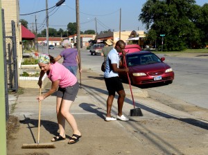 Above: Nicole Foster and Jay Johnson sweep the sidewalk during a neighborhood cleanup on Race Street.  Lisa Maria Garza