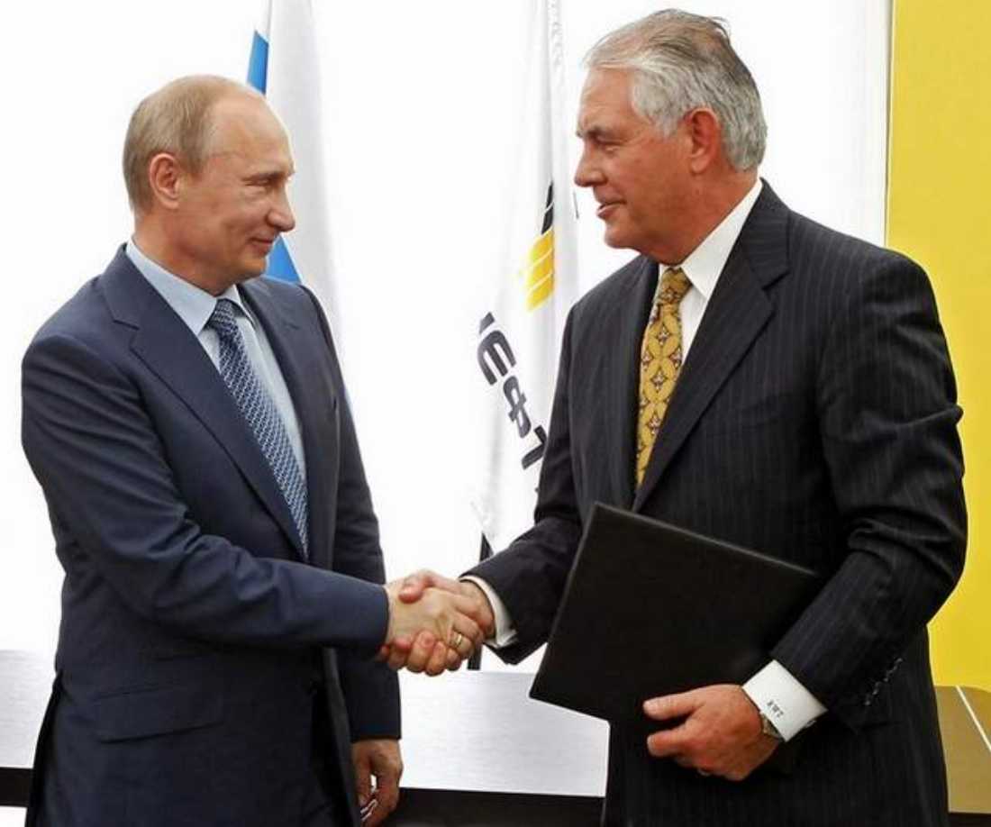 ExxonMobil CEO Rex Tillerson (right) shakes hands with Russian President Vladimir Putin