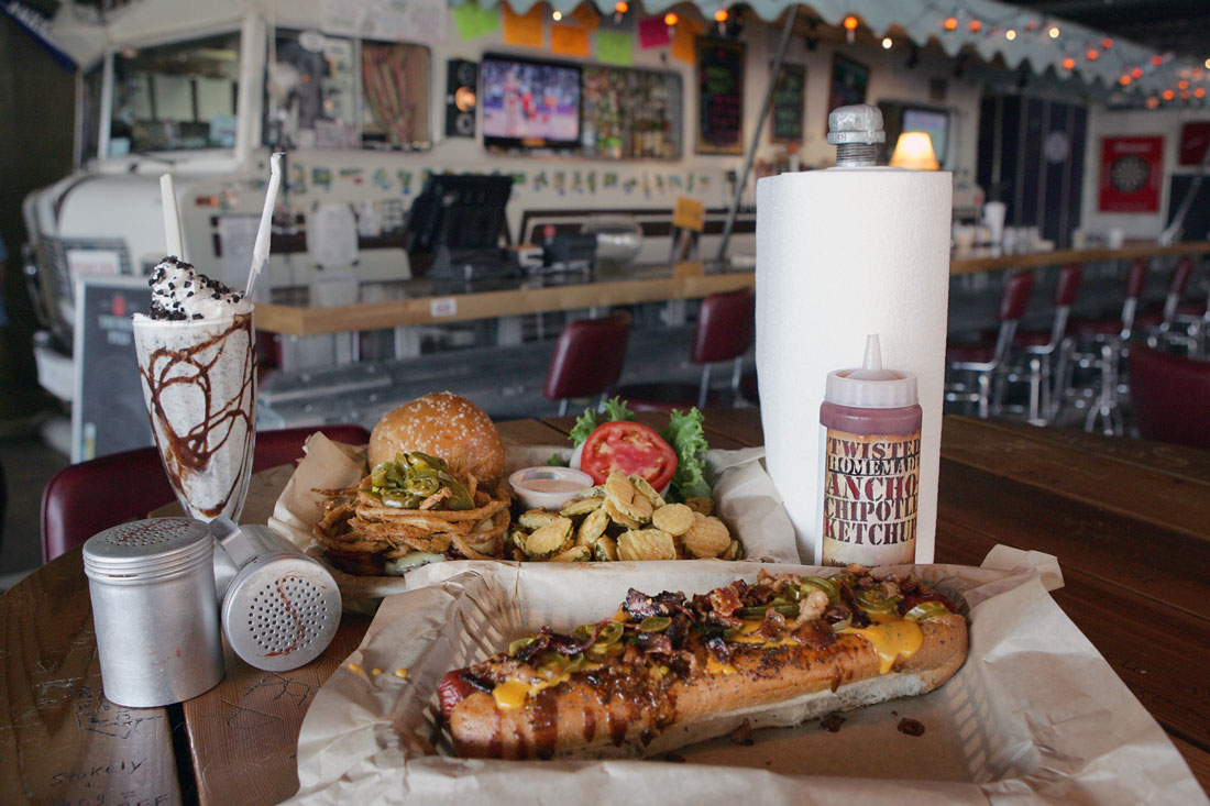 The Winnebago bar provides a quirky backdrop for some of Twisted Root’s signature items, including the Dirk Diggler Dog (front). Lee Chastain