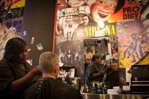 Monica Taylor cuts a customer’s hair at Floyd’s 99 Barbershop in Montgomery Plaza, surrounded by musical memorabilia. Chase Martinez