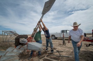 Tommy Houston (right) and helpers erect a windmill to pump water on his ranch in Erath County. 