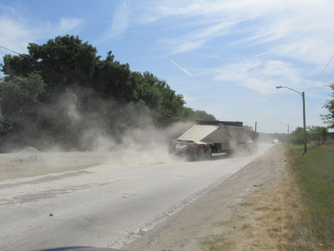 Another truck raises another cloud of dust on East First Street. Mike Phipps
