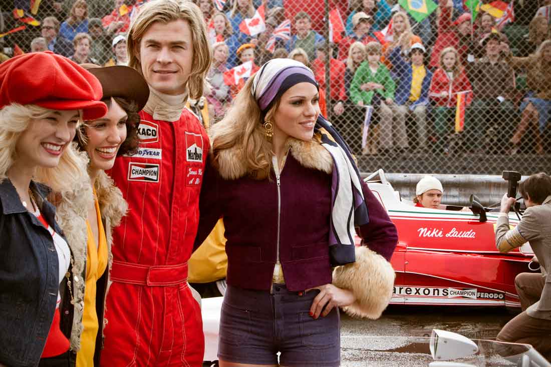 Chris Hemsworth hangs out with Formula One groupies while Daniel Brühl looks on in Rush.