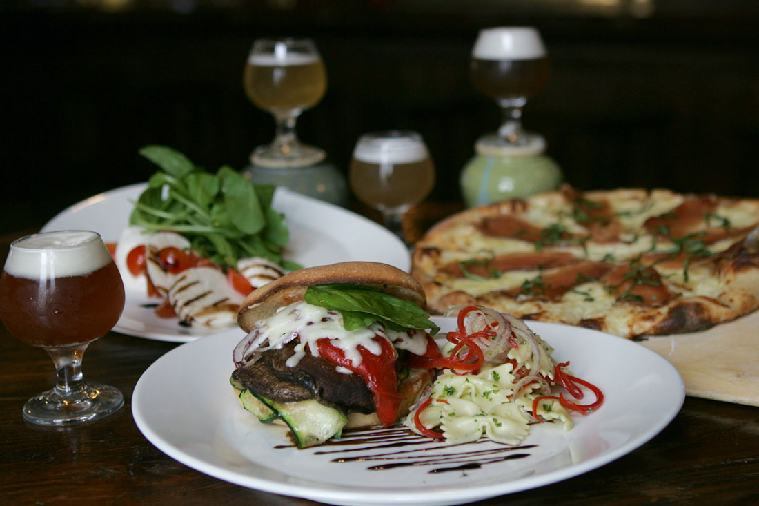 Along with a flight of house beers, Zio Carlo offers a mozzarella caprese appetizer (left), a portobello melt with pasta salad, and a scrumptious brie-and-speck pizza.