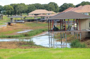 Boats hang high above the nearly dry lakebed, and docks look like storks standing in the mud.