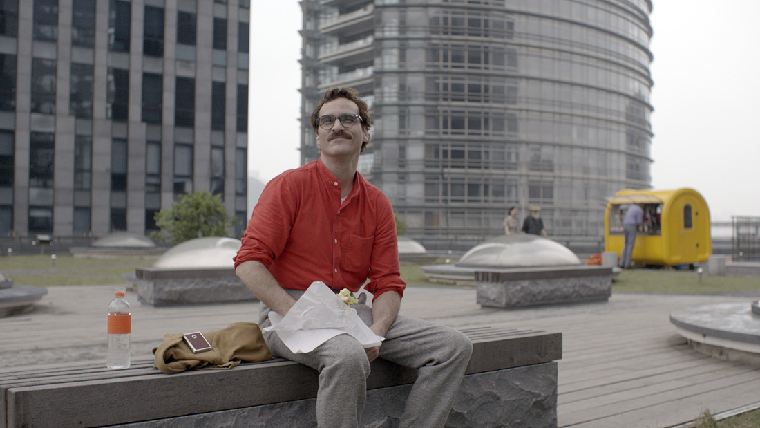 Joaquin Phoenix and Samantha (in smartphone, left) enjoy lunch outdoors in Her.