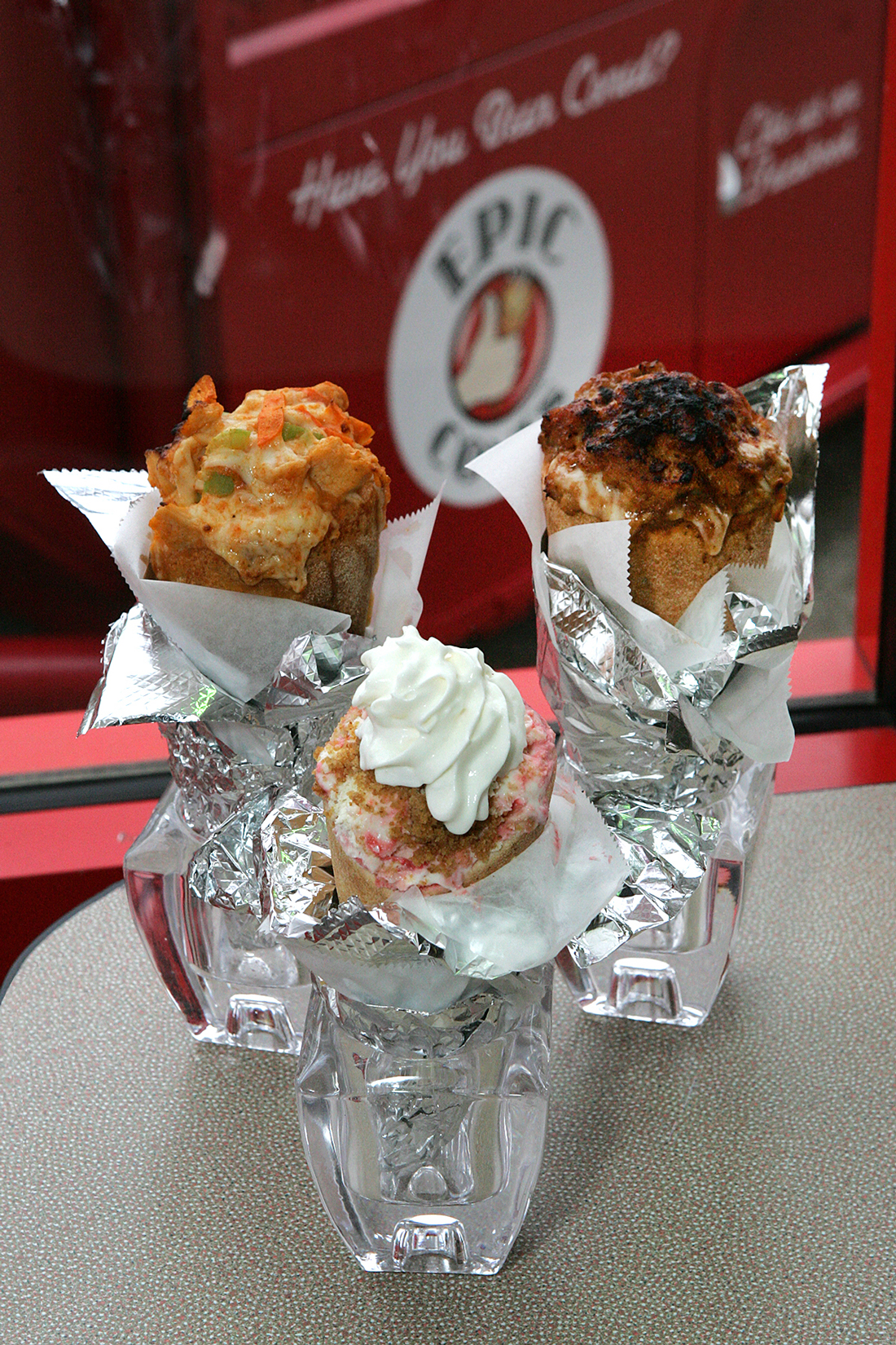 Strawberry cheesecake in a cone (center) isn’t all that surprising, but buffalo chicken (left) and pulled pork make a major statement at Epic Cones. Lee Chastain