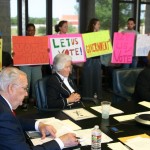 Protesters supporting Kelleher filled the board room while Vic Henderson (left), Marty Leonard, and Mary Kelleher discuss the censure.