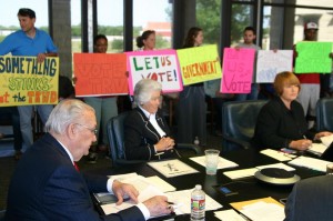 Protesters supporting Kelleher filled the board room while Vic Henderson (left), Marty Leonard, and Mary Kelleher discuss the censure.