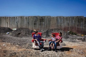 Two furniture makers in the West Bank take a break in chairs they have made.