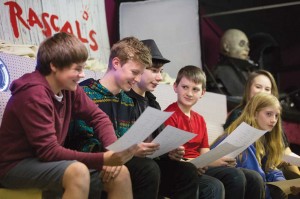 Students (left to right) Will Gassner, Kjell Pedersen, Levi Patton, McCormick Van Vleet, Maverick Knight, and Kaylee Yates find some humor in their scripts at rehearsal. 