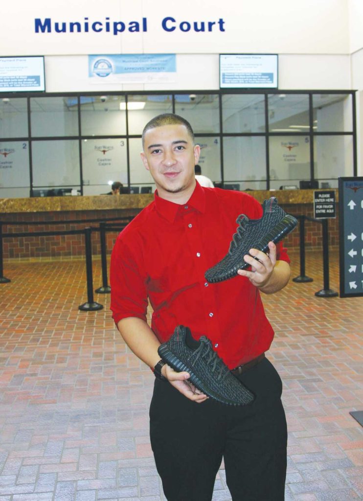 Ryan Perez holds the fake Yeezys after being awarded all of the sneakers in a property hearing. Photo by Jeff Prince.