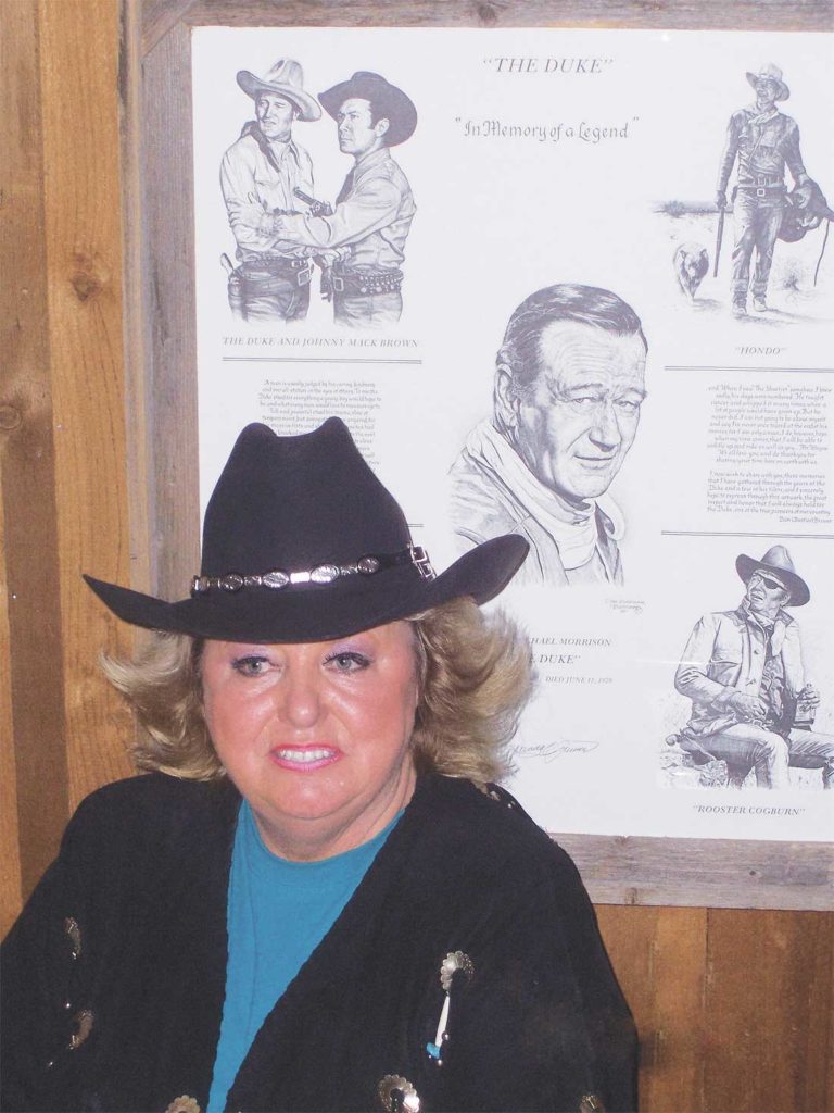 Arnold loved anything to do with the West, including Western movie star John Wayne, shown behind her on a poster that hung on her wall. Photo by Jef Prince.