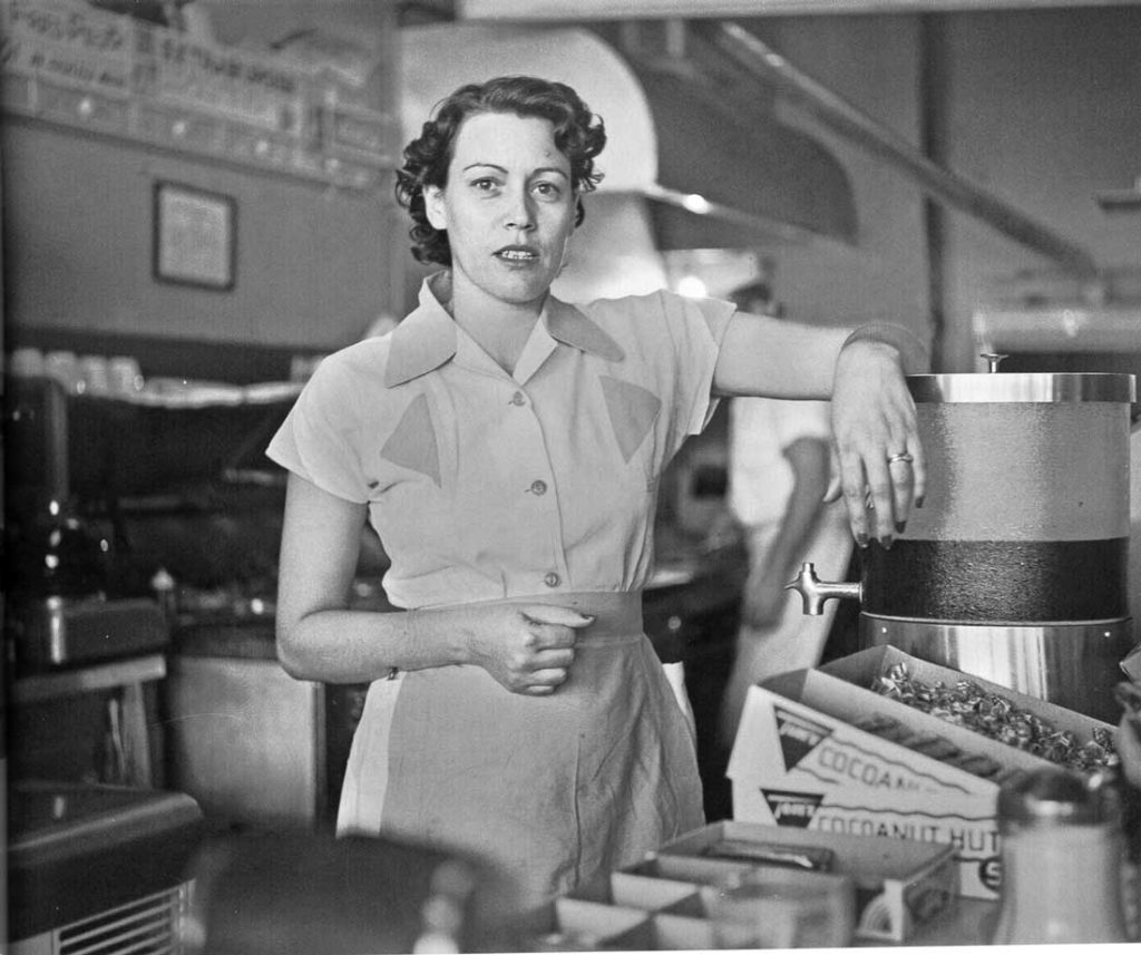 Byrd III photographed Susie Morgan, a co-owner with husband Ernie Morgan of Ernie’s Hamburger Stand, in 1955 in Fort Worth. The soft focus of the foreground and background, combined with Susie’s crisp uniform and the placement of her face in front of stainless steel oven hood makes her pop off the page.