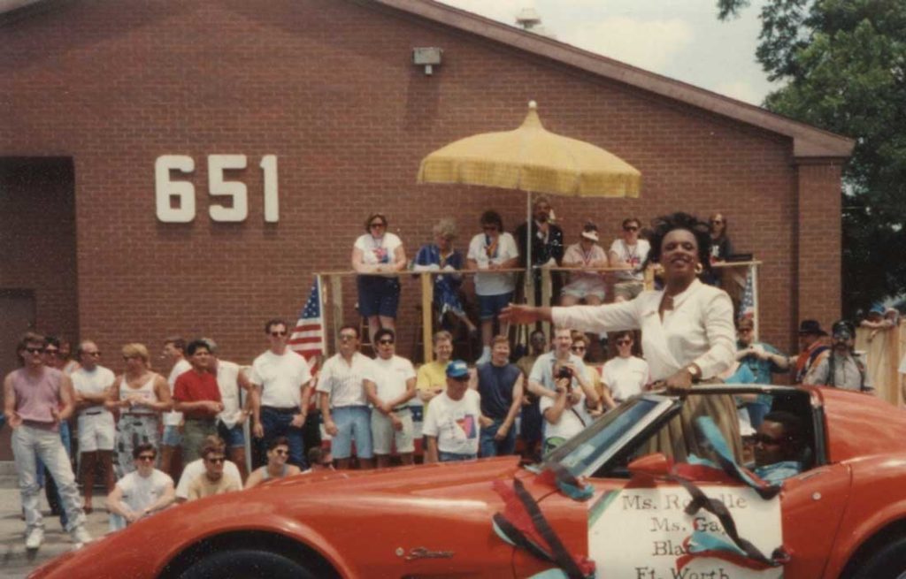 A Pride Parade shot from the ’80s shows how the parade viewing stand was right in front of the 651. That’s Ms. Ronelle, Ms. Gay Black Fort Worth, greeting onlookers while Raymond Gill announces in the background. From the collection of Todd Camp.