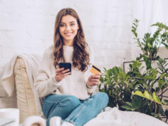 A young woman holding a calculator and a credit card.